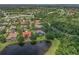 Stunning aerial view of the home with mature landscaping and a serene lake backdrop at 6959 Westchester Cir, Bradenton, FL 34202