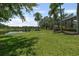 Beautiful backyard with green lawn, shady trees, and view of a lake, perfect for relaxing at 6959 Westchester Cir, Bradenton, FL 34202
