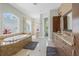 Luxurious bathroom features a soaking tub, large windows, and custom cabinetry at 6959 Westchester Cir, Bradenton, FL 34202