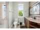 Bright bathroom featuring a toilet, vanity with storage, and a walk-in shower for a functional and pleasant space at 6959 Westchester Cir, Bradenton, FL 34202