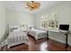 Cozy bedroom with two twin beds, a ceiling fan, hardwood floors, and a large window view at 6959 Westchester Cir, Bradenton, FL 34202