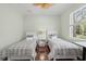 Cozy bedroom with two twin beds, wood floors, and natural light from the window at 6959 Westchester Cir, Bradenton, FL 34202