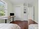 Bright bedroom with hardwood floors, built-in shelving, and a window providing natural light at 6959 Westchester Cir, Bradenton, FL 34202