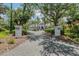 Beautiful home exterior with a long driveway, mature trees, and meticulous landscaping at 6959 Westchester Cir, Bradenton, FL 34202