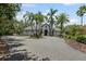 Expansive front exterior of the home, including the circular driveway and lush palm trees at 6959 Westchester Cir, Bradenton, FL 34202