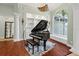 Grand piano takes center stage in this elegant living room with custom built-ins and large window at 6959 Westchester Cir, Bradenton, FL 34202