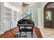 Grand piano takes center stage in this elegant living room with custom built-ins and large window at 6959 Westchester Cir, Bradenton, FL 34202
