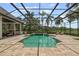 A sparkling screened-in pool is surrounded by luxurious stone tiling with outdoor seating, ideal for relaxation at 6959 Westchester Cir, Bradenton, FL 34202