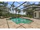 Stunning screened-in pool surrounded by lush landscaping and a brick patio, perfect for outdoor relaxation at 6959 Westchester Cir, Bradenton, FL 34202