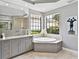 Bright bathroom with an oval soaking tub and large windows at 7037 Brier Creek Ct, Lakewood Ranch, FL 34202