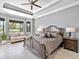 This bedroom boasts tray ceilings, a cozy loveseat, and ample natural light at 7037 Brier Creek Ct, Lakewood Ranch, FL 34202