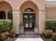 Arched entryway featuring double doors with glass panels, and manicured landscaping at 7037 Brier Creek Ct, Lakewood Ranch, FL 34202