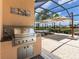 Outdoor kitchen area with a built-in stainless steel grill, countertop, and storage, perfect for summer barbecues at 7037 Brier Creek Ct, Lakewood Ranch, FL 34202