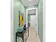 Hallway featuring an accent wall, decorative art, and views into the laundry room at 7037 Brier Creek Ct, Lakewood Ranch, FL 34202