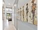 Hallway displaying artwork, tray ceilings, and access to the primary bedroom at 7037 Brier Creek Ct, Lakewood Ranch, FL 34202