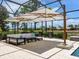 Outdoor lounge area with comfortable seating, a large umbrella, and serene landscaping, ideal for relaxation and entertainment at 7037 Brier Creek Ct, Lakewood Ranch, FL 34202