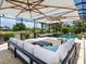 Luxury poolside lounge area with comfortable seating and an elegant umbrella, perfect for outdoor relaxation and entertaining at 7037 Brier Creek Ct, Lakewood Ranch, FL 34202