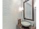 Chic powder room features a unique vessel sink, decorative mirror, and textured wallpaper at 7037 Brier Creek Ct, Lakewood Ranch, FL 34202