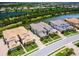 Aerial view showcasing a community with multiple homes, lush greenery, and a picturesque lake at 7387 Divot Loop # 15-D, Lakewood Ranch, FL 34202