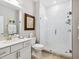 Well-lit bathroom featuring a glass-enclosed shower with textured tile and a vanity with stone countertop at 7387 Divot Loop # 15-D, Lakewood Ranch, FL 34202