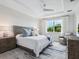 Comfortable bedroom featuring tray ceiling and large window views at 7387 Divot Loop # 15-D, Lakewood Ranch, FL 34202
