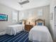 Cozy bedroom with two twin beds, stylish area rug, and bright natural light from shuttered windows at 7387 Divot Loop # 15-D, Lakewood Ranch, FL 34202