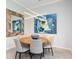 Dining room features a modern light fixture, striking mirror, and contemporary art at 7387 Divot Loop # 15-D, Lakewood Ranch, FL 34202