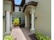 Welcoming condo entrance with a brick pathway, white columns, and decorative plants at 7387 Divot Loop # 15-D, Lakewood Ranch, FL 34202