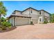 Exterior view of a multi-story home with a large driveway and three-car garage at 7387 Divot Loop # 15-D, Lakewood Ranch, FL 34202