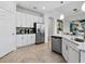 Well-lit kitchen features stainless steel appliances, white cabinetry, and ample counter space at 7387 Divot Loop # 15-D, Lakewood Ranch, FL 34202