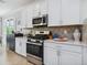 Modern kitchen featuring stainless steel appliances and white cabinetry at 7387 Divot Loop # 15-D, Lakewood Ranch, FL 34202