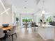 Bright open-concept living space with sleek tile flooring, dining area, and sliding glass doors to the outside at 7387 Divot Loop # 15-D, Lakewood Ranch, FL 34202