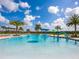 Resort-style pool featuring shallow play areas, lush palms, and comfortable poolside seating at 7387 Divot Loop # 15-D, Lakewood Ranch, FL 34202