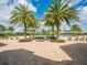 Beautiful pool area with palm trees, lounge chairs, and spacious brick paver surround at 7387 Divot Loop # 15-D, Lakewood Ranch, FL 34202