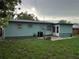 View of the home's backyard, featuring lawn and a light blue exterior at 7555 15Th N St, St Petersburg, FL 33702