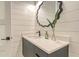 Chic powder room with a gray vanity, modern sink, and decorative mirror, enhanced by shiplap walls at 8006 20Th W Pl, Bradenton, FL 34209