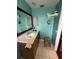 This turquoise bathroom features a vanity with a mirror, and a stool at 853 Albritton Ave, Sarasota, FL 34232