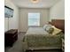 Bright bedroom featuring a bed with tropical-patterned bedding and natural light from the window at 8995 Milestone Dr, Sarasota, FL 34238