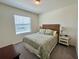 Bright bedroom featuring a bed with tropical-patterned bedding and natural light from the window at 8995 Milestone Dr, Sarasota, FL 34238