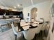 Open floor plan featuring a dining table with seating for eight, a kitchen island, and dark cabinetry at 8995 Milestone Dr, Sarasota, FL 34238