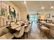 Elegant dining area with a large modern art piece, seating for eight, and open access to the living area at 8995 Milestone Dr, Sarasota, FL 34238