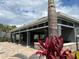 A charming outdoor kitchen area with a stone counter, covered area with ceiling fans, and outdoor seating at 8995 Milestone Dr, Sarasota, FL 34238