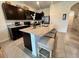 Charming kitchen features dark cabinets, granite countertops, and a spacious central island with barstool seating at 8995 Milestone Dr, Sarasota, FL 34238