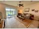 Bright living room boasts sliding glass doors leading to a patio, a ceiling fan, and a comfortable seating arrangement at 8995 Milestone Dr, Sarasota, FL 34238