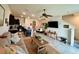 Open-concept living room and kitchen area featuring a dining table, television and staircase at 8995 Milestone Dr, Sarasota, FL 34238