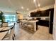 Open-concept kitchen with a center island, seating, modern appliances, and seamless flow into the living area at 8995 Milestone Dr, Sarasota, FL 34238