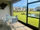 Screened patio features a table with seating offering views of a community pond at 8995 Milestone Dr, Sarasota, FL 34238