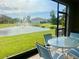 Screened patio features a table with seating offering views of a community pond with a fountain at 8995 Milestone Dr, Sarasota, FL 34238