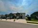 Neighborhood street view showcasing townhomes with garages, landscaped front yards, and well-maintained lawns at 8995 Milestone Dr, Sarasota, FL 34238