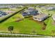 Spacious backyard with green lawn, landscaping, mature trees, and a view of the neighboring houses at 9292 Tequila Sunrise Dr, Sarasota, FL 34241